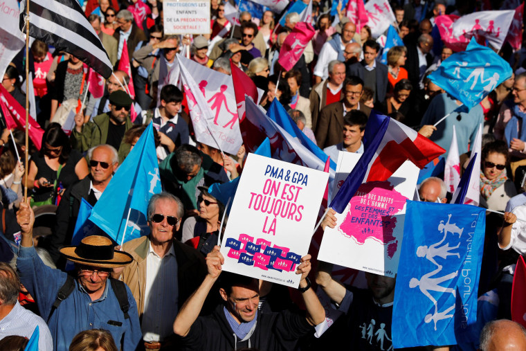 Image: People wave flags and hold signs with messages as demonstrators take part in a protest