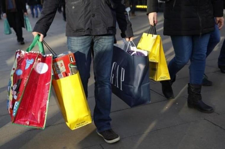 Shoppers carry bags along Oxford street during the final weekend of shopping before Christmas in London