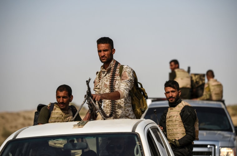 Image: Members of Iraqi forces drive their vehicles, as they head to the frontline