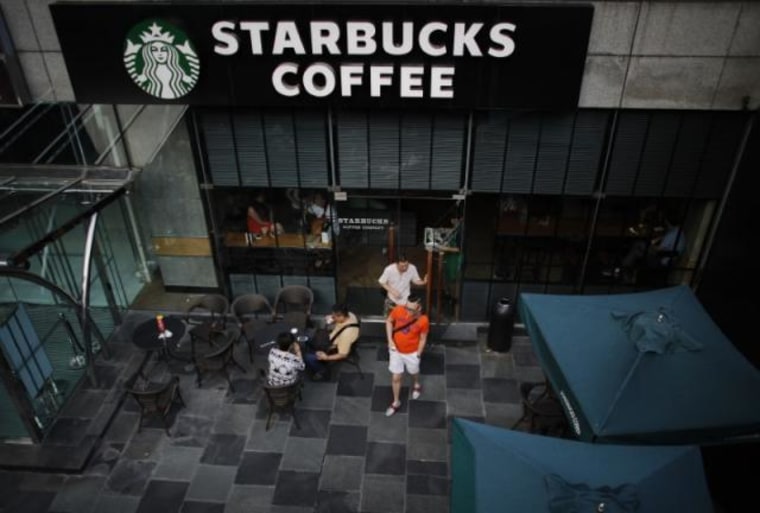 Customers walk out of a Starbucks coffee store in Shanghai