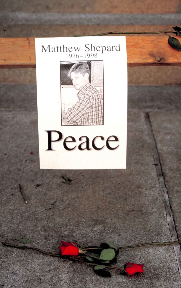 Memorial roses and a poster during vigil for for Matthew Shepard