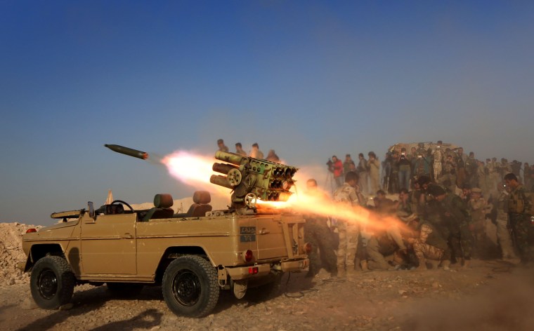 Image: Iraqi Kurdish peshmerga fighters fire a multiple rocket launcher