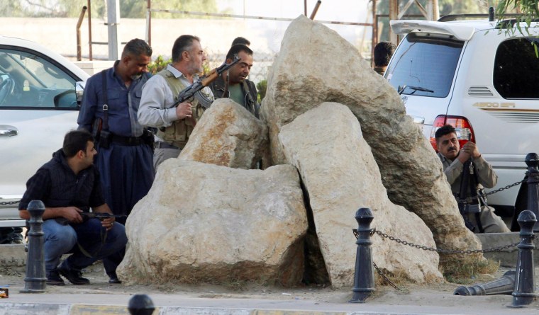 Image: Peshmerga forces stand behind rocks in Kirkuk