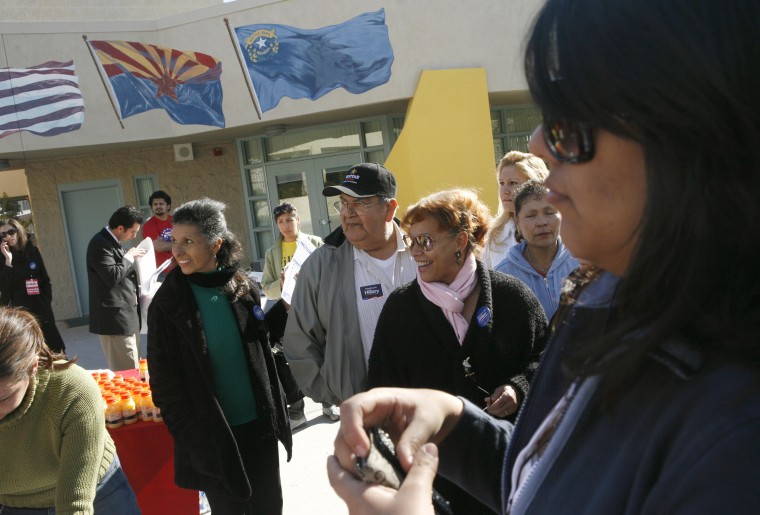 David Morales and Silvia Raposo (C) line up for registration at a caucus precinct 19 January 2008 in East Las Vegas, Nevada.
