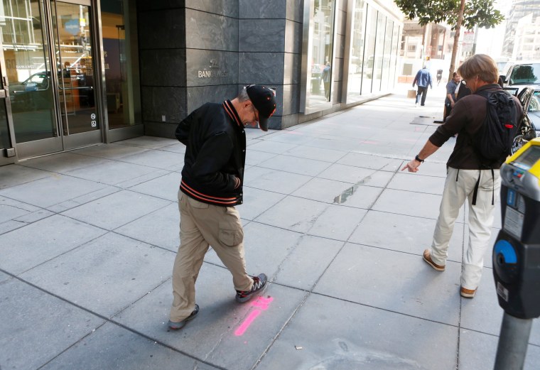 Image: Pedestrians inspect cracks near the sinking Millennium Tower in San Francisco, California