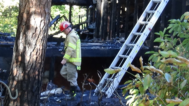 Image: A firefighter inspects the scene of the fire