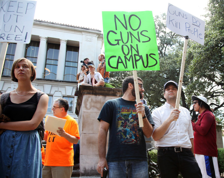 Image: Students holds signs as they protest a campus carry law