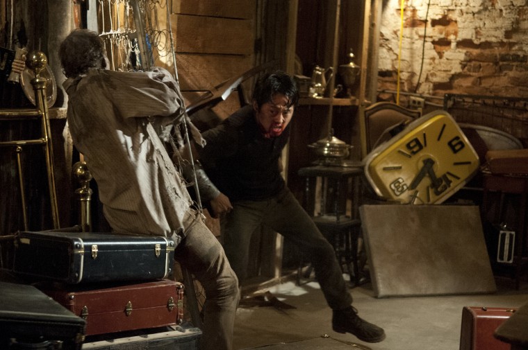 Glenn Rhee, played by Steven Yeun, does battle with a walker in episode seven of season three of "The Walking Dead"