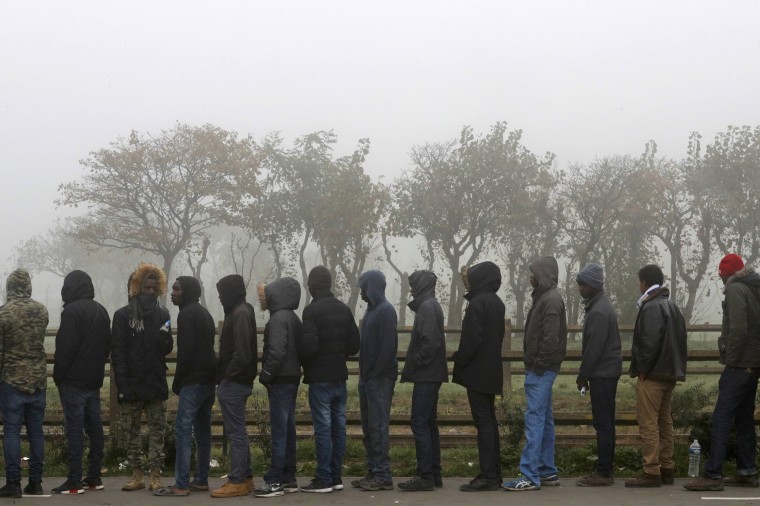 Image: Migrants line up on the third day of evictions from the "Jungle" in Calais, France.