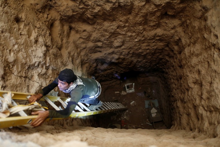 Image: An Iraqi special forces soldier climbs down into a tunnel used by Islamic State militants inside a house in  Bartalla, east of Mosul
