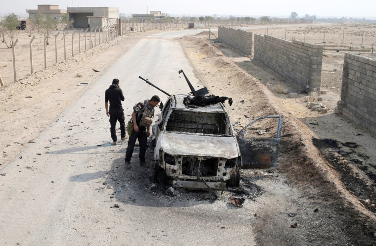 Image: Iraqi special forces soldiers looks at a destroyed Islamic State vehicle in a village near Mosul