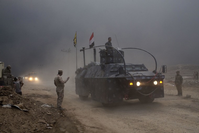 Image: An Iraqi Federal Police vehicle passes through a checkpoint in Qayara