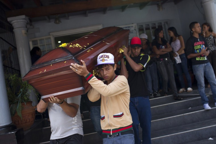 Image: Relatives of a crime victim carry his coffin during his funeral ceremony in Caracas