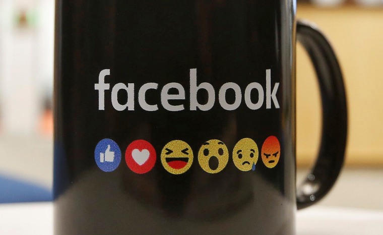The Facebook logo and emoticons are seen on a coffee mug at the reception of its new office in Mumbai