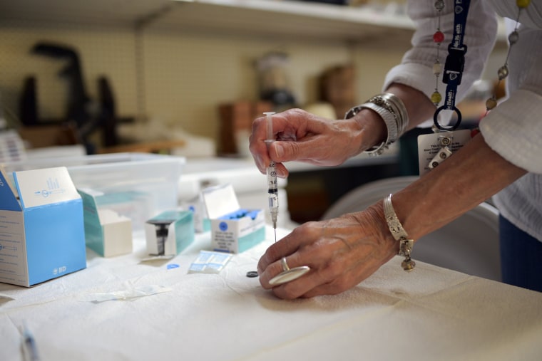 Image: Jacqueline Fletcher prepares a dose of the measles, mumps and rubella (MMR) vaccine