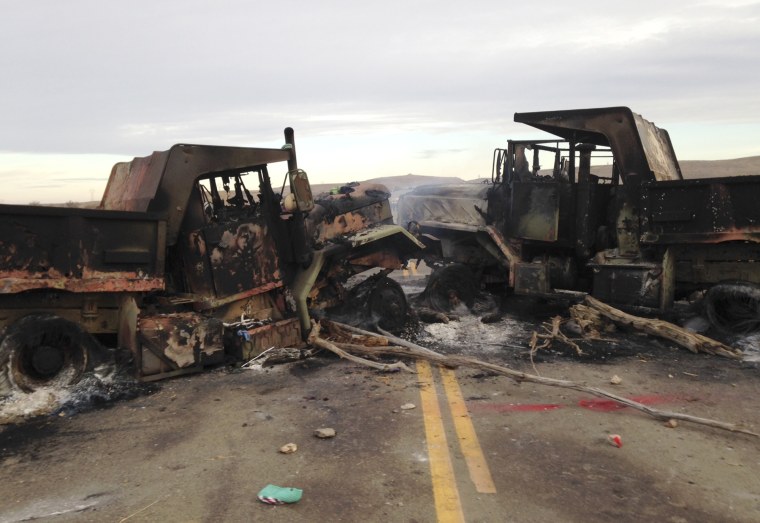 The burned hulks of heavy trucks sit on Highway 1806 near Cannon Ball, N.D., on Friday, Oct. 28, near the spot where protesters of the Dakota Access pipeline were evicted from private property a day earlier. Authorities say protesters burned several pieces of construction equipment Thursday during a chaotic confrontation with law enforcement.