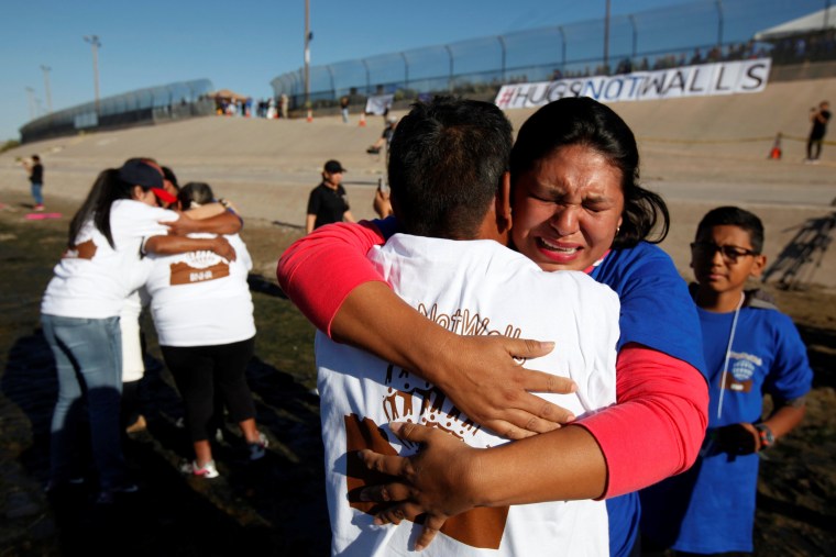 Image: Relatives separated by deportation and immigration hug at the border during a brief reunification meeting at the banks of the Rio Bravo, a natural border between U.S. and Mexico