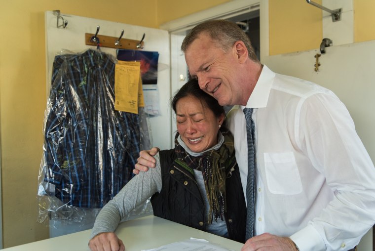 Jacque Yee, a fourth generation family member to operate Ching Lee Laundry, hugs a long-time customer on October 29, 2016, the day the shop closed its doors.