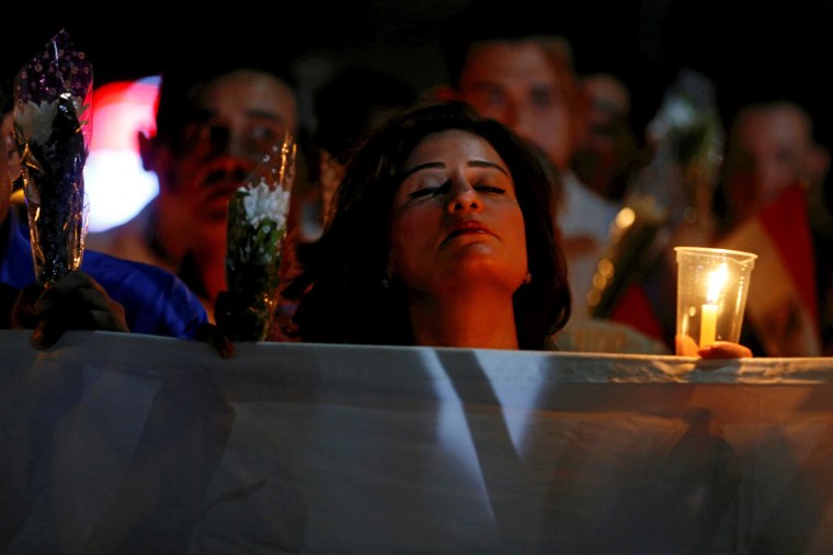 Image: A woman reacts while marching with candles to the \"Peace Square\" during a ceremony to mark the first anniversary of the Russian MetroJet plane crash in the Red Sea resort of Sharm el-Sheikh