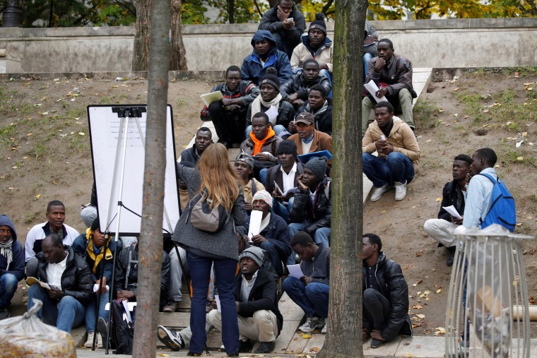 Image: Migrants attend a French lesson near their makeshift camp in Paris, France