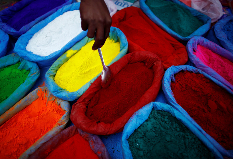 Image: A street vendor spreads vermilion powder used for worship during the Tihar festival, also called Diwali, in Kathmandu