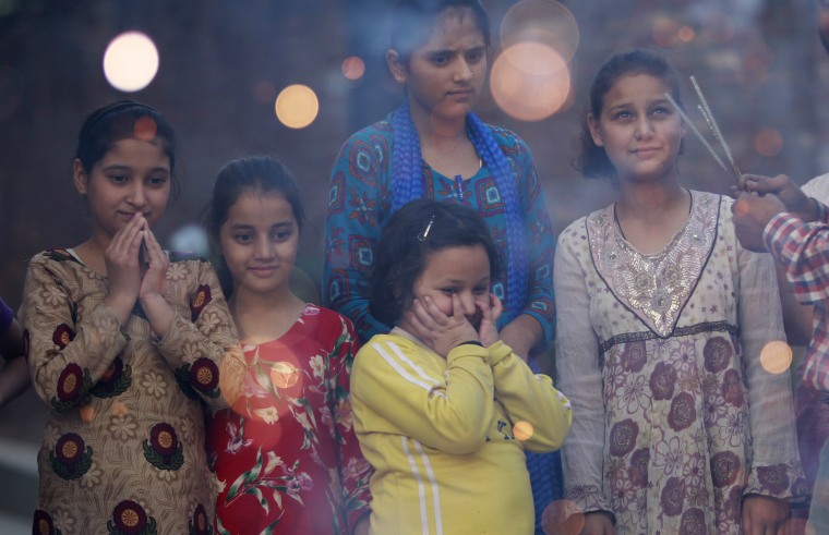 Image: Children watch firecrackers being lit on the eve of Diwali