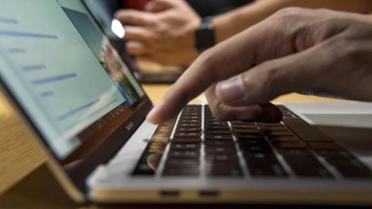 An attendee demonstrates the Touch Bar on a new MacBook Pro laptop computer during an event at Apple headquarters in Cupertino, California.