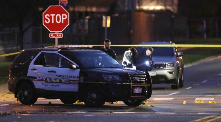 Image: Police officers gather evidence at the scene of a shooting in Urbandale, Iowa