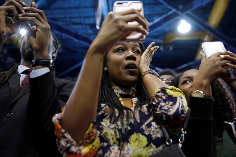 Image: A woman wipes away tears as Obama delivers remarks at a campaign event in Miami