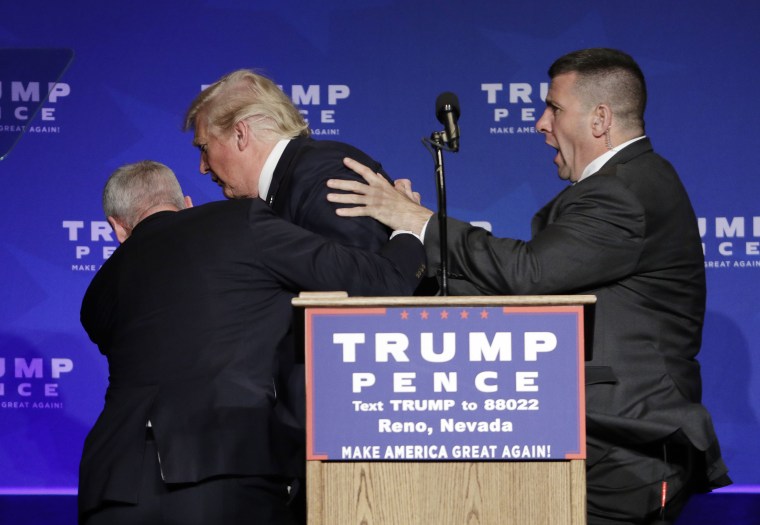 Members of the Secret Service rush Republican presidential candidate Donald Trump off the stage at a campaign rally in Reno, Nev., on Saturday, Nov. 5, 2016.