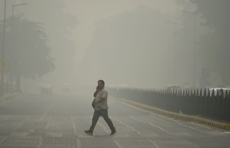 Image: An Indian pedestrian walks through heavy smog in New Delhi, Sunday.