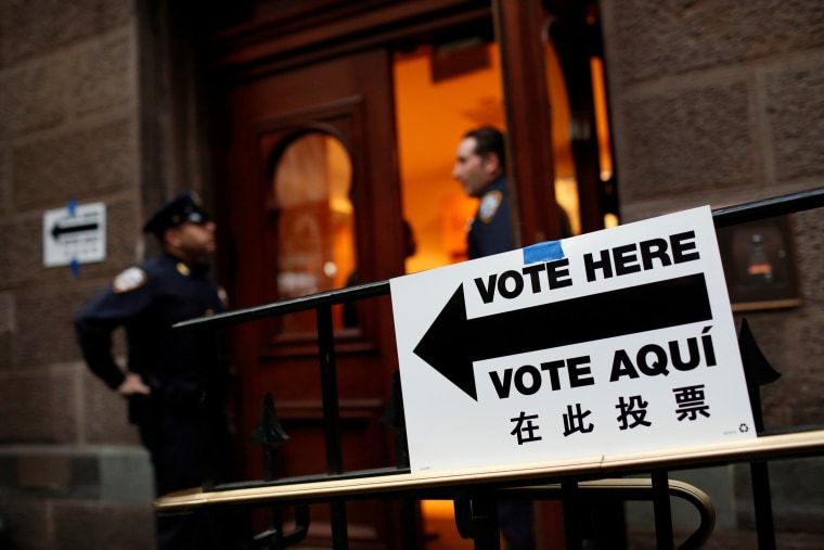Image: Members of the New York police guard an entrance at a polling station as voting opened for the New York primary elections in the Manhattan borough of New York City