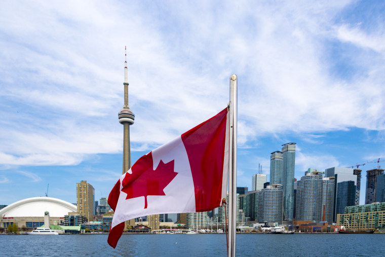 Canadian flag and the Toronto skyline. The flags waves from