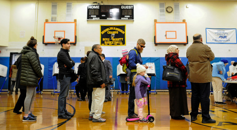 Image: Muslim couple stand in line to collect their ballots during election day in Brooklyn, New York