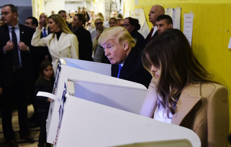 Image: Trump and his wife Melania fill out their ballots at a polling station