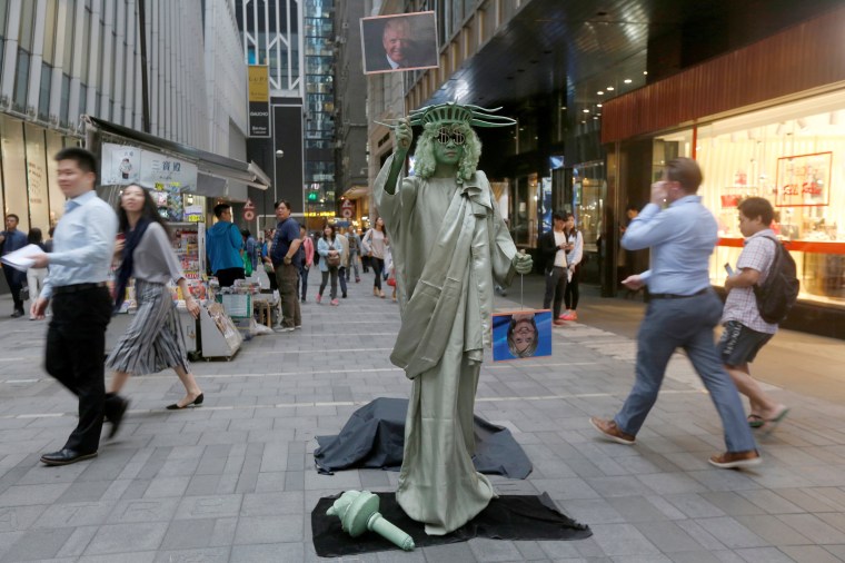 Image: A street performer dressed as the Statue of Liberty in Hong Kong