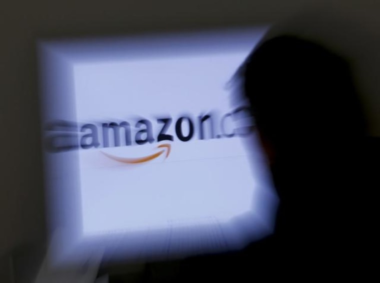 A zoomed illustration image of a man looking at a computer monitor showing the logo of Amazon is seen in Vienna