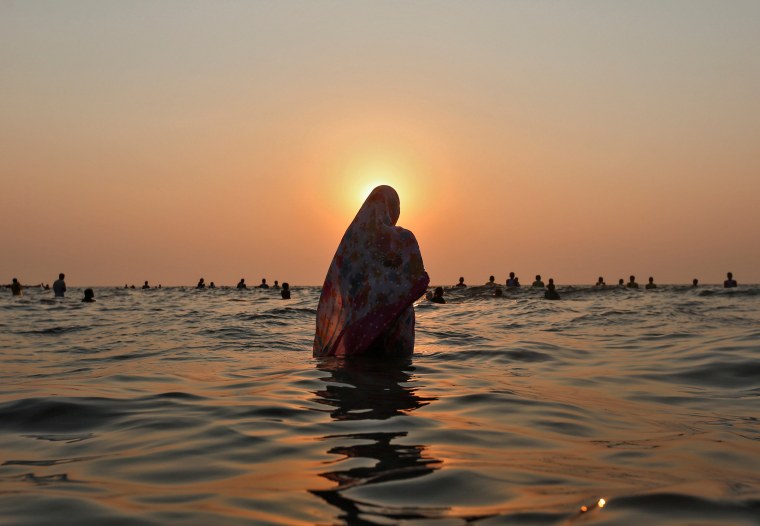 Image: Hindu devotees worship the Sun god in the waters of the Arabian Sea during Chhath Puja in Mumbai