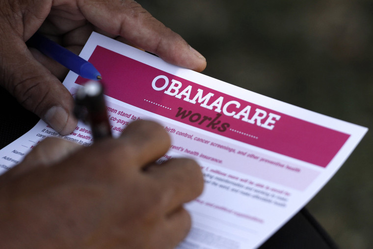 Image: A man fills out an information card during an Affordable Care Act outreach event hosted by Planned Parenthood for the Latino community in Los Angeles, California