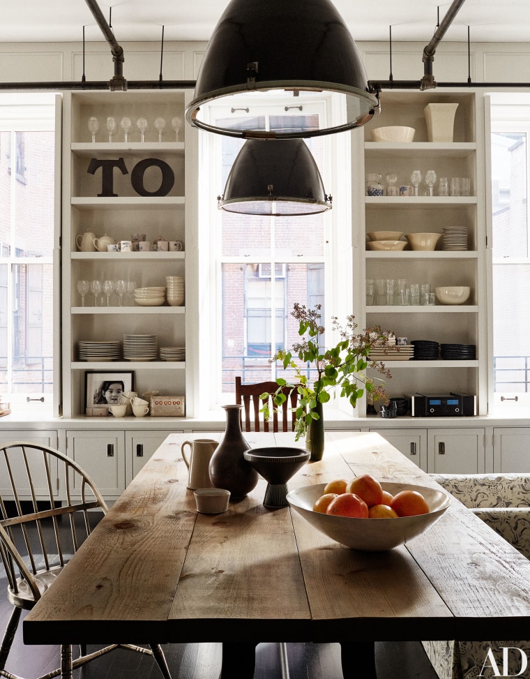 Industrial lights from a salvage shop in Maine illuminate the kitchen’s dining area.