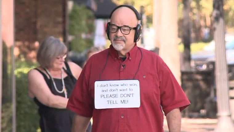 Joe Chandler has gone to extreme measures to avoid learning the results of the presidential election, including wearing a sign that reads, "I don't know who won, and don't want to. Please don't tell me.”