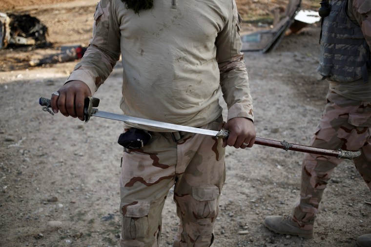 Image: An Iraqi soldier holds a sword
