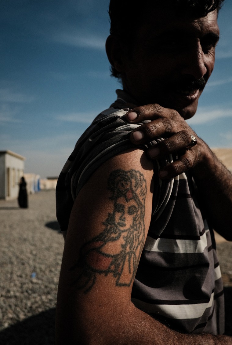 Image: Khalid Ibrahim, 37, shows off his tattoo