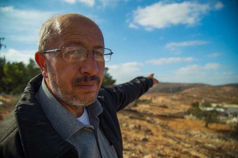 Image: Ibrahim Yacoub, points to DzAmonadz, the Israeli settlement