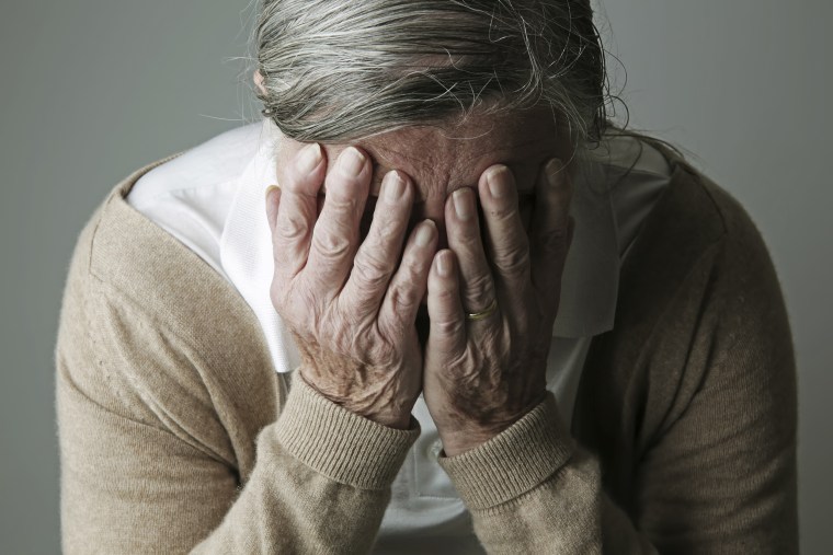 Image: Elderly woman covering face with her hands