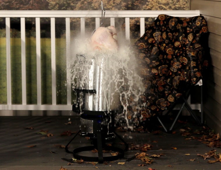 Image: Frozen turkey is dropped into a deep fryer at a food safety demonstration in Rockville