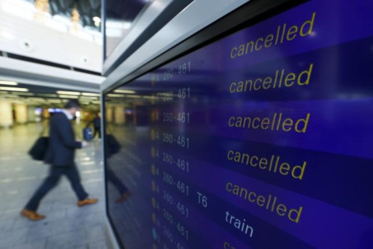 A passenger walks past a flight information board showing cancelled flights during a pilots strike of German airline Lufthansa at  Frankfurt airpor