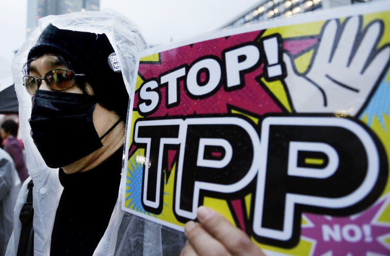 Image: A protester holds a placard during a rally against the Trans-Pacific Partnership (TPP) in Tokyo