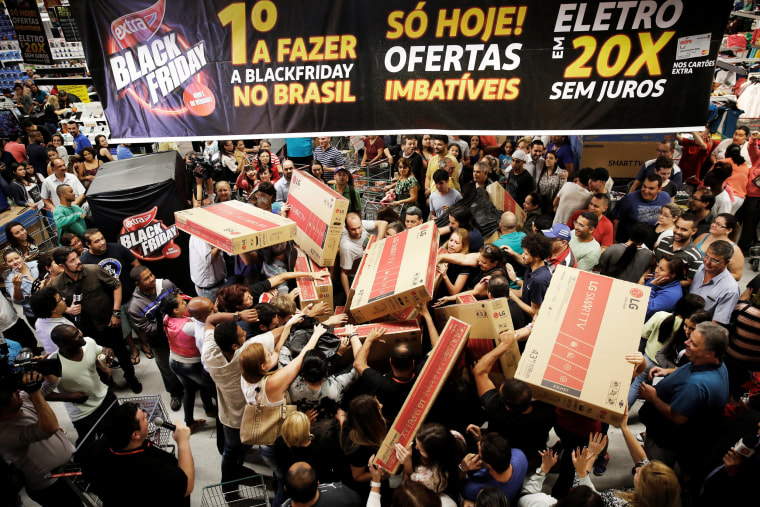 Image: Shoppers reach out for television sets as they compete to purchase retail items on Black Friday at a store in Sao Paulo