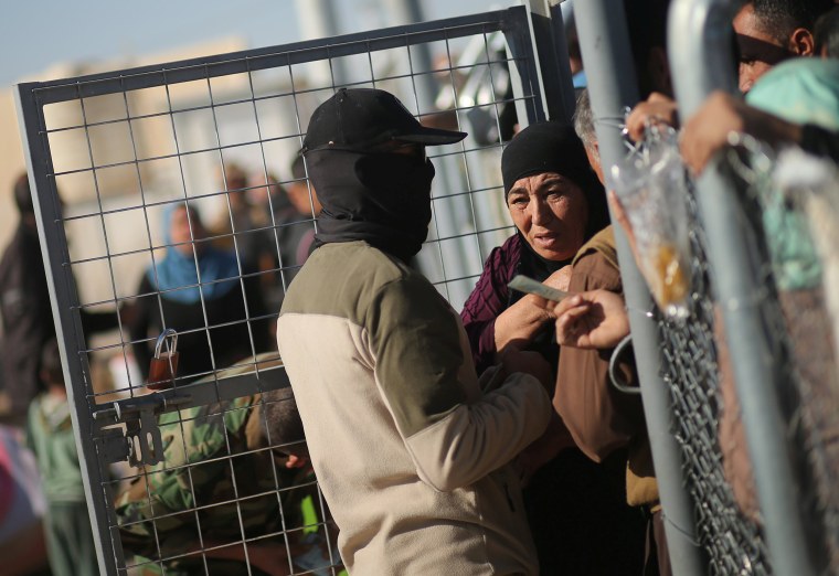 Image: Newly displaced Iraqis, who fled the Islamic State stronghold of Mosul, wait to be allowed to enter Khazer camp